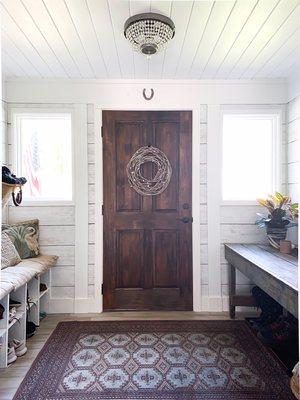 Custom stained solid ash door, shiplap walls, laminate flooring and bench with cubbies...this used to be an open-air porch!