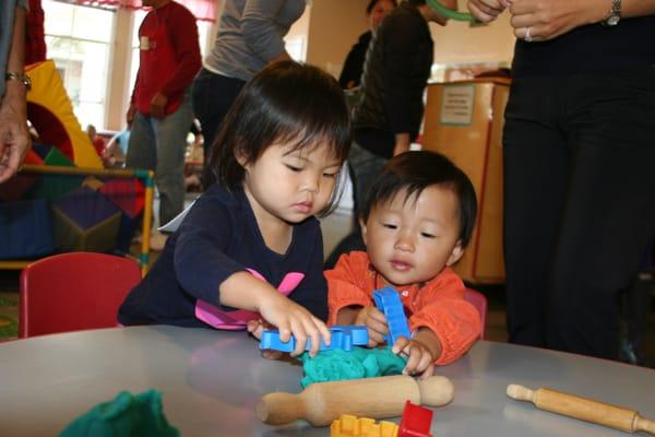 Sensory experiences like playing with play-dough and using tools help toddlers get comfortable with new sensations.