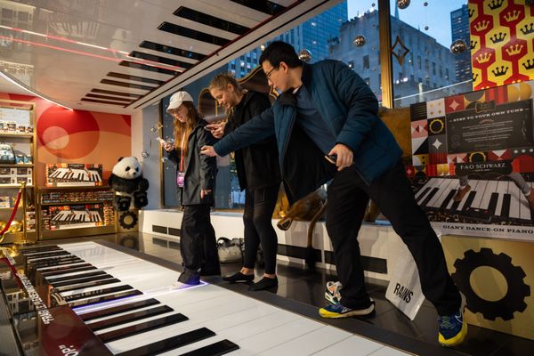 A Compass 2023 team plays a giant piano