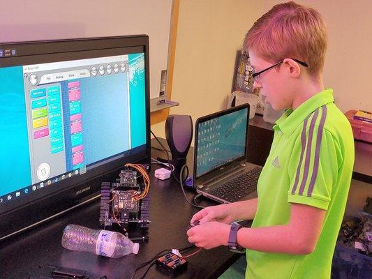 Programming a robot we built to pick up water bottles. Very handy!