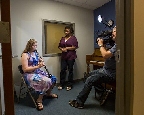 Jennifer R demonstrates her clarinet skills to instructor Kiendra Chester. They're not nervous at all, even with a cameraman in the room.