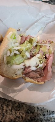 Large roast beef sub with pickles, lettuce, tomatoes, onions, and American cheese