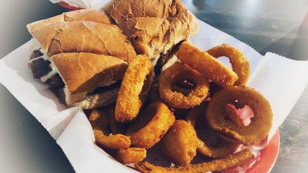 Whole hot Italian sausage sandwich with cheese, pizza sauce, and hot peppers.  And onion rings.