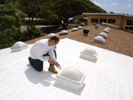 A white cool roof coating over asphalt shingles