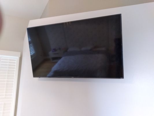 A 65" TV mounted on a full motion wall mount.