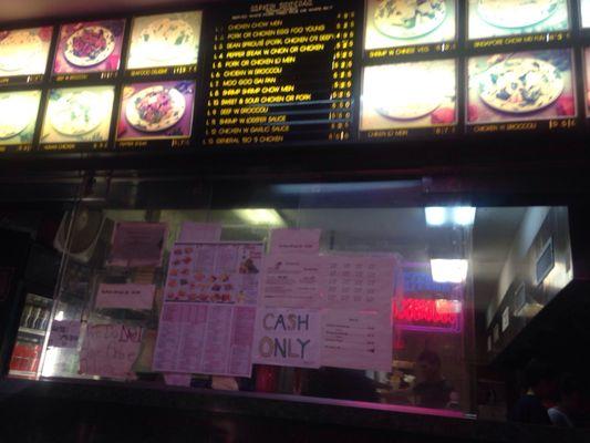 Menu board and assorted signs on the bulletproof glass