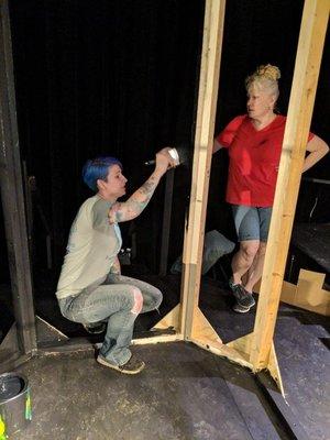 Parents help with sets before a show.  The supportive actions from the parents to see their kids thrive within the theatrical surroundings.