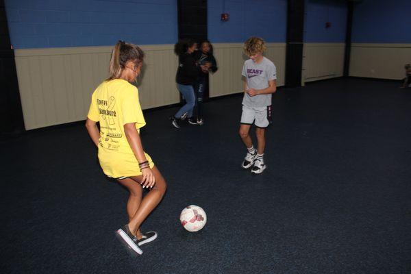 Students playing soccer in the gym.