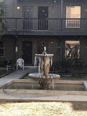 picture of the fountain in front of apt covered in ice while snowing. :)