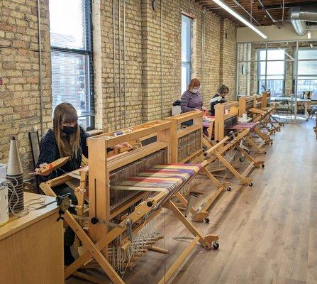 Students weaving on floor looms.