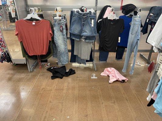 Women's clothing and loose clothes and hangers on the floor.