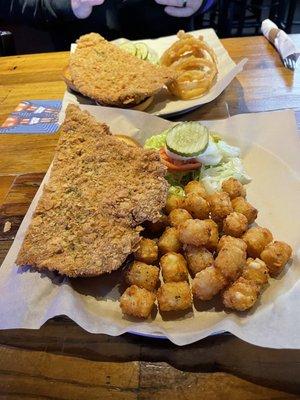 Pork Tenderloin Sandwich Half order.  One with onion rings & the other with Tator Tots.