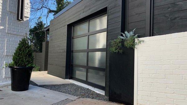 Bike shed built into the side of a hill with a green roof.