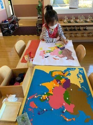 The child is working on making her own Asia map