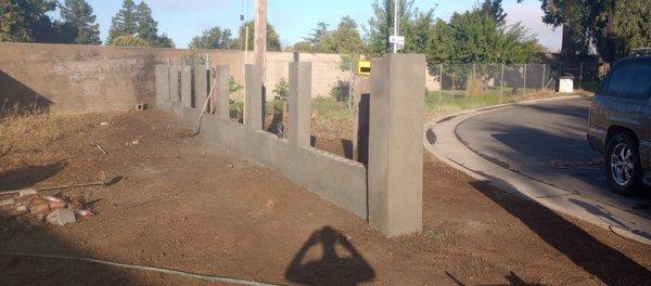 Filled concrete cinder block fence. Customer wanted offense more protective than their previous one. Corrugated steel will be in between