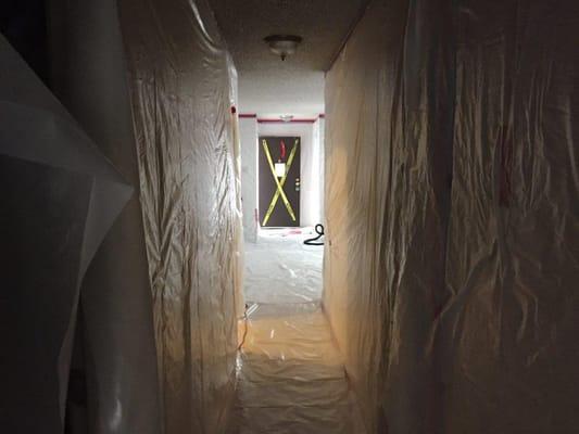 Inside asbestos containment.  Setup prior to acoustic removal from a fire insurance claim.  Contents and inventory were all prior completed.