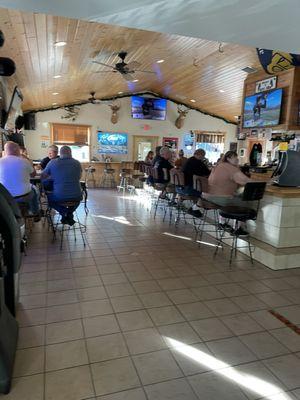 Big, L-shaped bar with a few high tables.