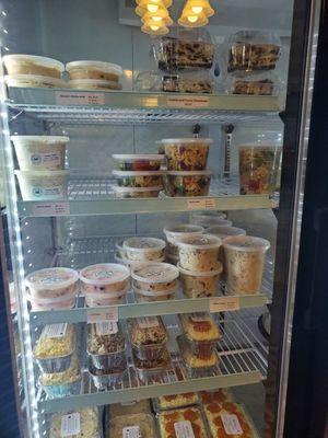 Fridge filled with chicken salad, pasta salad, cakes, pies etc