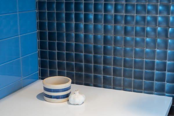 A beautiful combination of pillow ceramic tiles, glass tiles and quartz for a tactile, warm kitchen