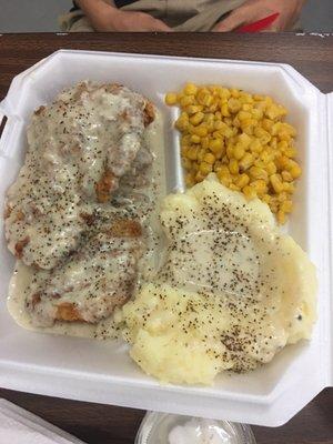 Chicken fried chicken with homemade gravy all around and mashed potatoes & whole corn.