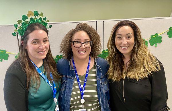 3 people smile during the St. Patrick's Day event