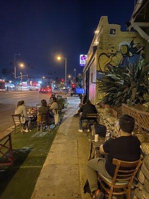 Sidewalk seating with a tv at the end.  Not bad