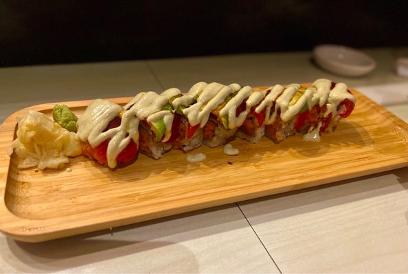 Maguro Invictus Crunchy spicy tuna roll with tuna sashimi & avocado on top, drizzled in edamame puree