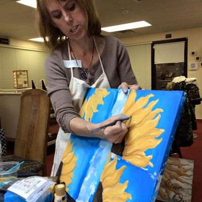 Molly teaching how to paint a sunflower.  Yes we do painting classes too!