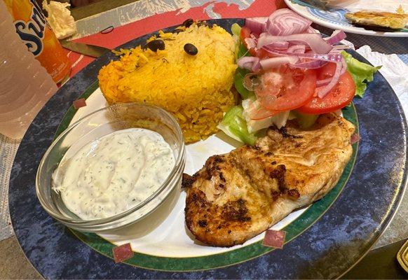 Marinated grilled chicken over rice, salad, and tzatziki sauce.