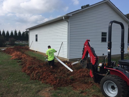 Installing underground downspout drain pipes