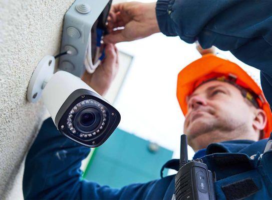 Technician installing an outdoor security camera