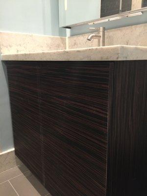 Custom vanity faced with Ebony Macassar (installed horizontally on front and vertically on side) topped with Cesarstone (Mother of Pearl)