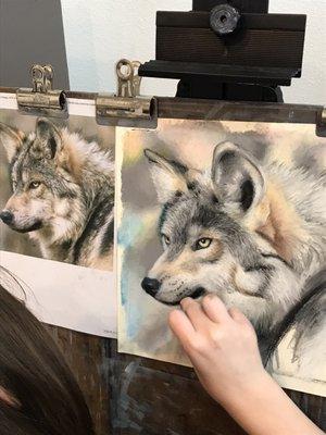 Nika, age 12, drawing a wolf with pastels.