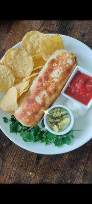 Freshly wrapped and seared ground turkey burrito with freshly sliced avocado and homemade salsa with a side or tostitos and sour cream