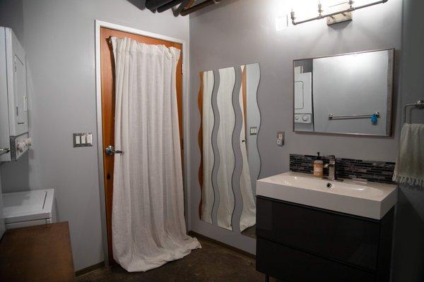 Bathroom with shower, washer and dryer.