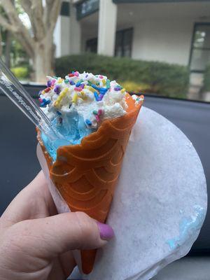 Orange creamsicle waffle cone with magical unicorn icecream.  Homemade whipped cream with sprinkles on top.