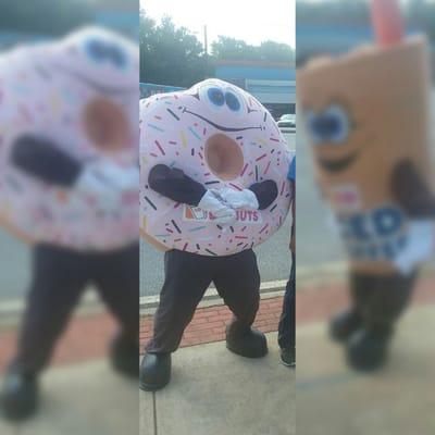 The dunkin mascot cuppy and sprinkles on their grand opening day .