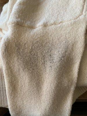 how my WHITE sweater came back, with some kind of burn mark or something dirty