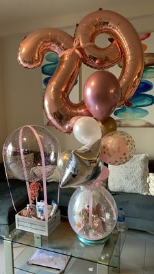 Stuffed balloon with coco chanel perfume, Victoria secret products and a number balloon bouquet on top.