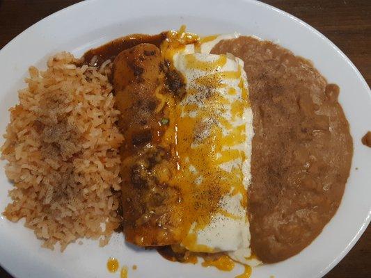 Chicken and beef enchilada with rice and refried beans.