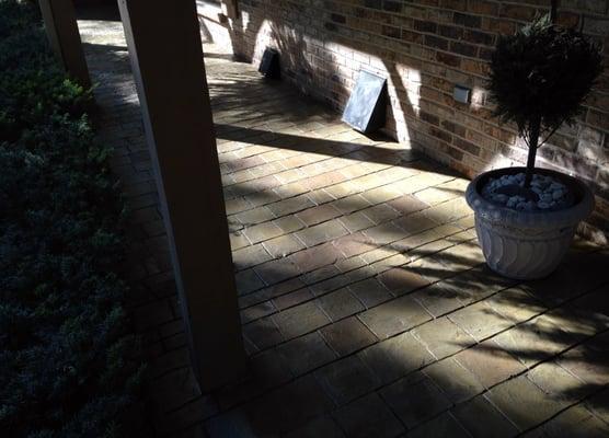 Stamped concrete overlay porch featuring a hand stain to create a classical antiqued look.