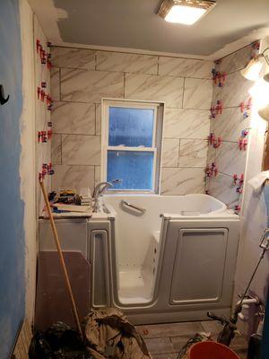 This is a new American Standard walk in Tub with new tile surround , and new plank tile floors