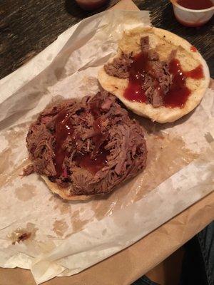 Generously packed brisket sandwich with some red B-B-Q sauce