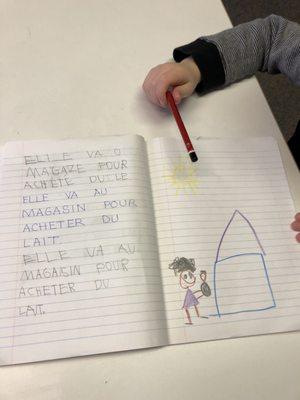 Journaling in Kindergarten develops literacy.  "Elle va o magaze pour achete du le." (Elle va au magasin pour acheter du lait).