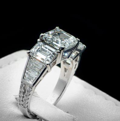 Asscher center diamond with side emerald cut diamonds engagement ring.