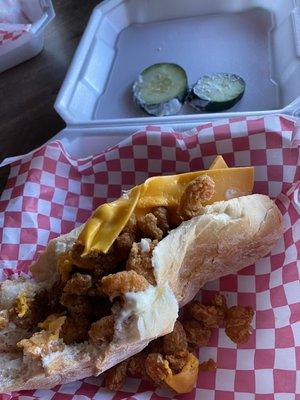 Shrimp po'boy with cheese and cucumbers thrown on top.