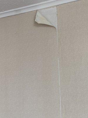 Paper peeling from the wall near the ceiling