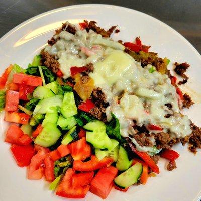 House salad topped with steaks, Mixed peppers and cheese