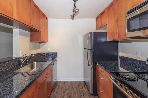 Beautifully Remodeled Kitchens equipped with stainless steel appliances and blue pearl granite countertops.