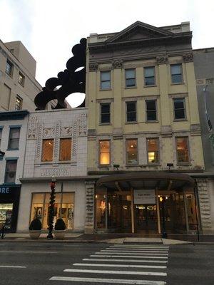 Front of the building, from across the street. White building houses the gallery.